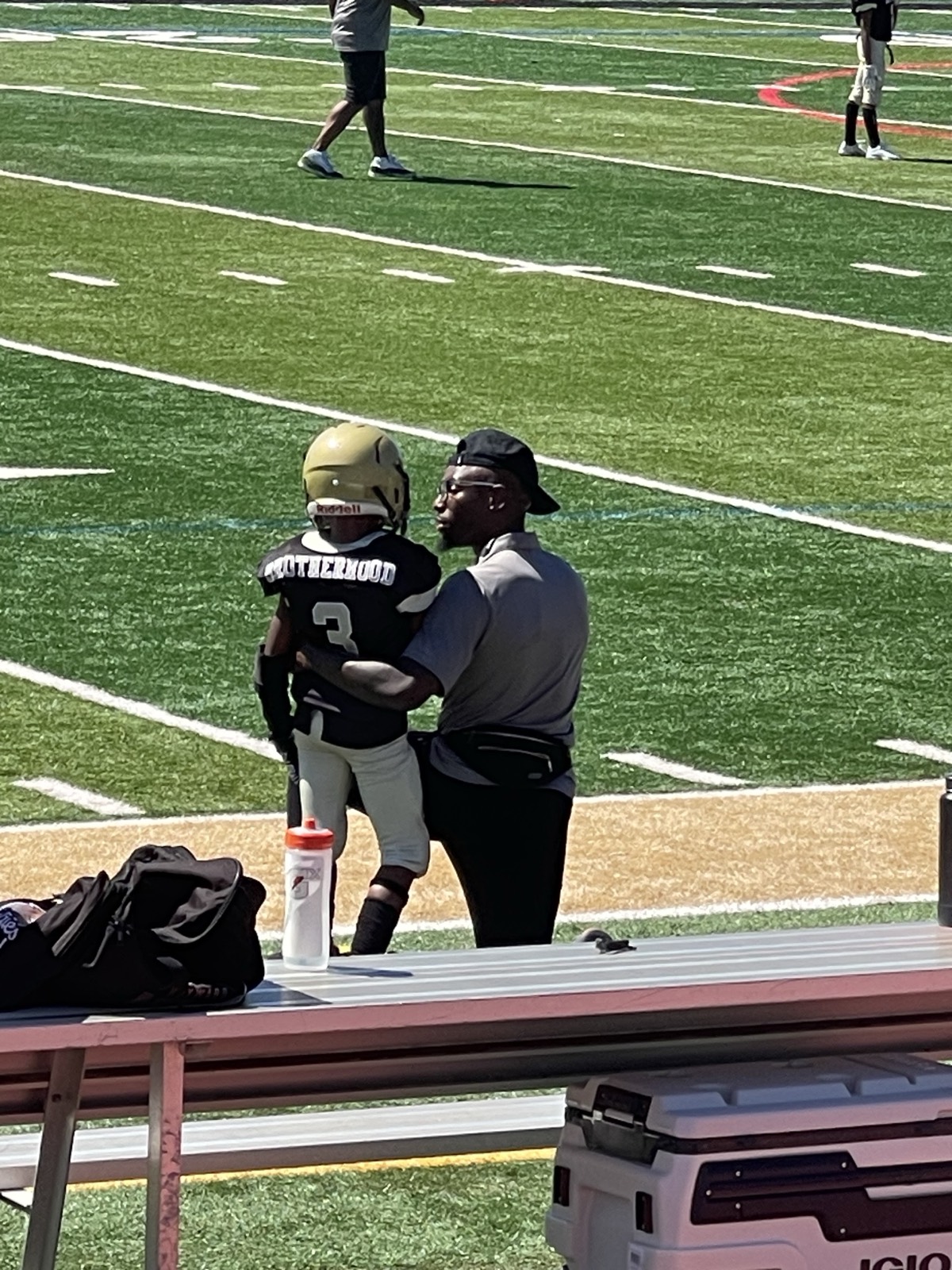 Coach Trammell coaching a defensive back on the sideline